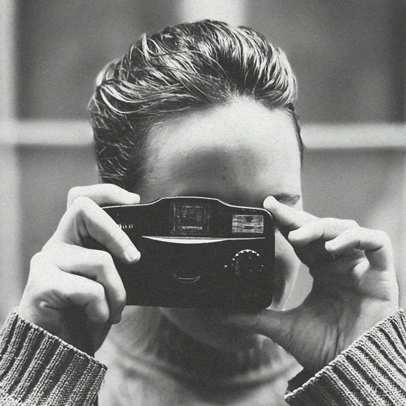 Femme qui prend une photo avec un appareil argentique compact