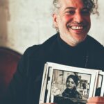 Homme souriant qui présente ses tirages noir et blanc