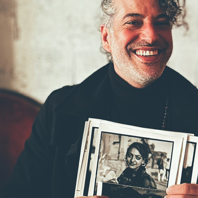 Homme souriant qui présente ses tirages noir et blanc
