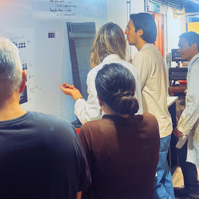 Groupe de participants réunis devant un tableau blanc pendant un cours collectif de photo argentique