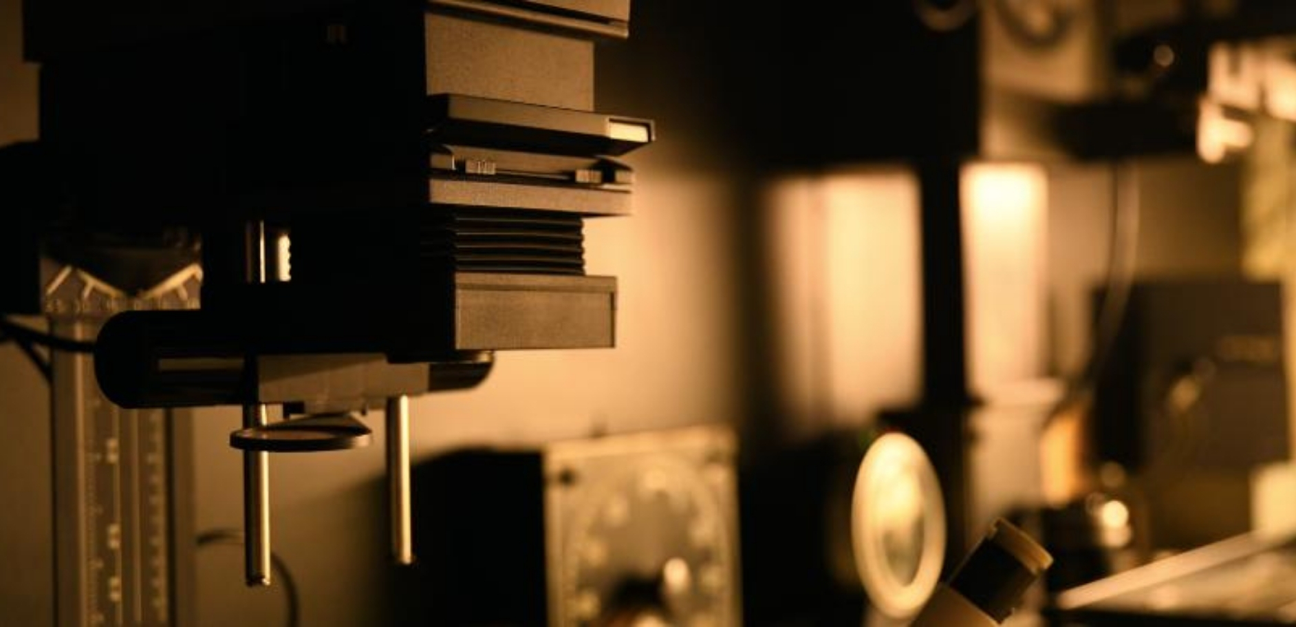 Agrandisseur photo dans la pénombre du labo, éclairé par la lumière inactinique