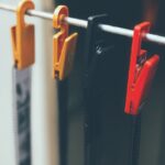 Bandes de négatifs suspendues au séchage par des pinces jaunes, noire et rouge
