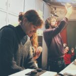 Participants du photo-club au labo, l'un d'eux examine un négatif à la lumière
