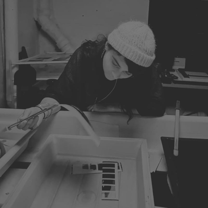 Femme en bonnet qui contrôle ses tirages dans le bac de lavage